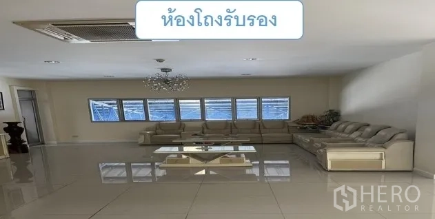 货栈 出租在Mueang Pathum Thani, Pathum Thani - 接待休息区，转角沙发、吊灯与窗墙