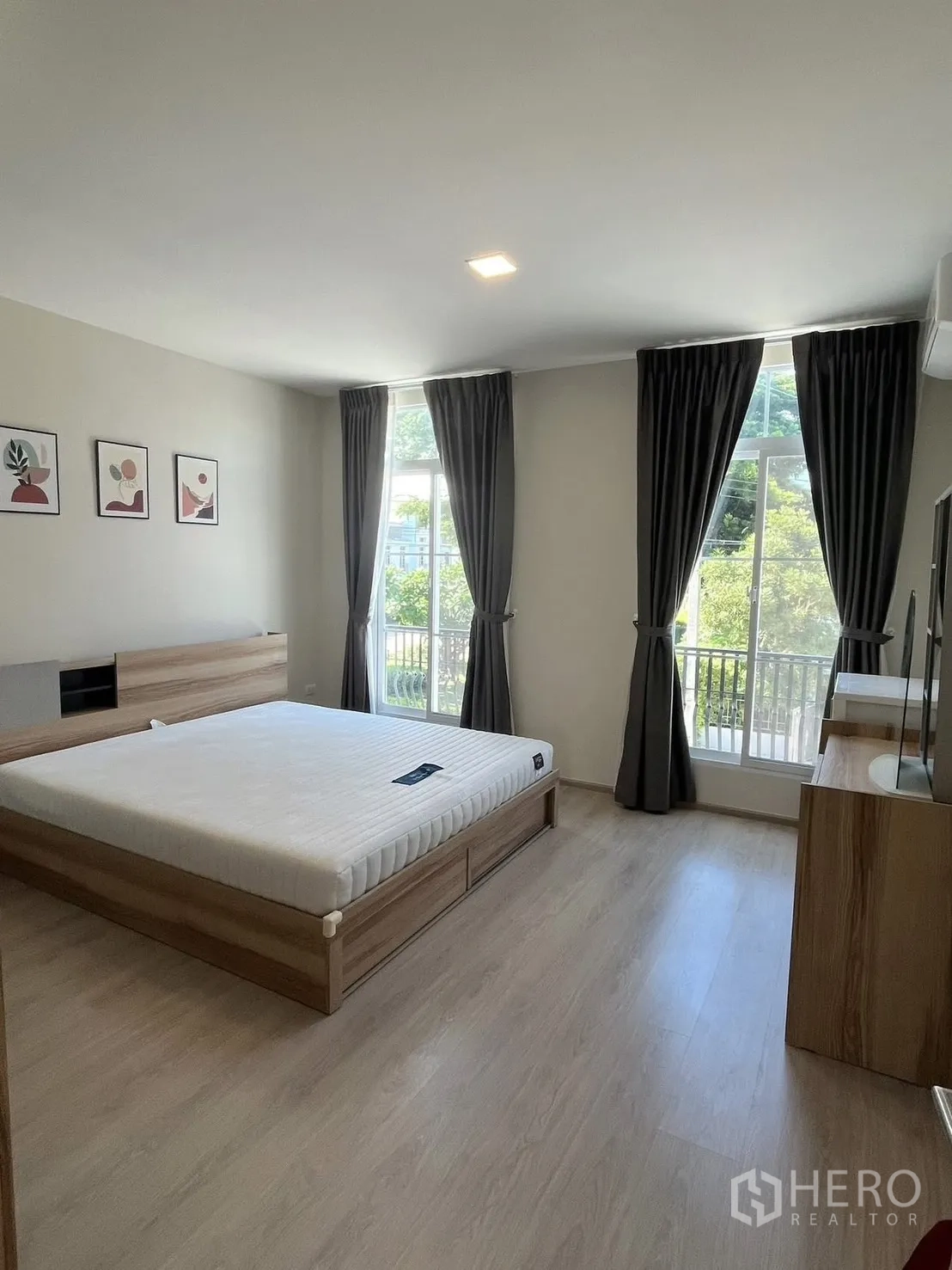 联排别墅 for rent in Prawet, Bangkok - 主卧设大窗、窗帘与木纹地板。