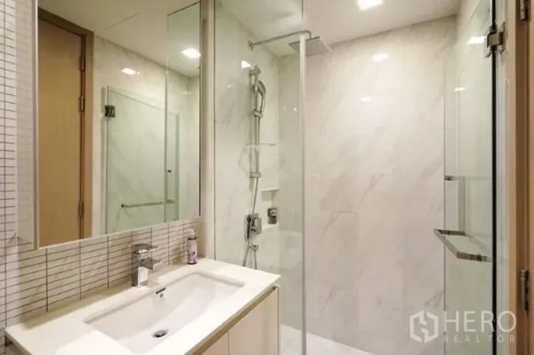 คอนโด ให้เช่าในWatthana, Bangkok - ห้องน้ำสไตล์โมเดิร์น ผนังลายหินอ่อน ตู้กระจกกั้นอาบน้ำพร้อมเรนชาวเวอร์ และอ่างล้างหน้าพร้อมตู้กระจก