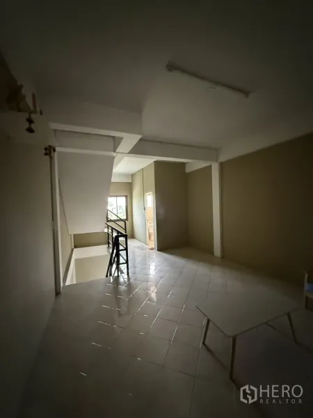 Shophouse for rent in Pak Kret, Nonthaburi - Tiled landing area with staircase and doorway to bathroom.