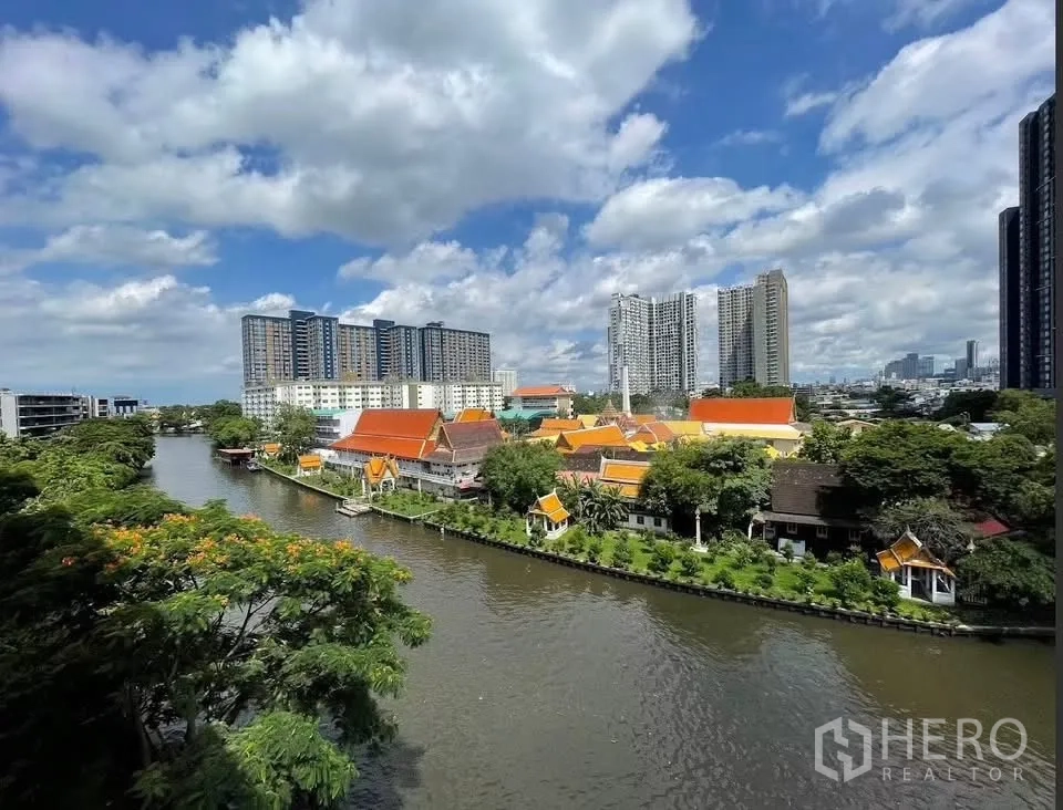 Condominium for rent in Watthana, Bangkok - Elevated view of canal and traditional orange-roof buildings with modern condos beyond.
