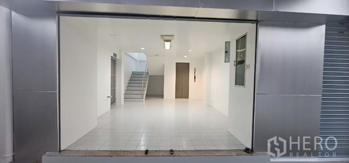 办公空间 出租在Bueng Kum, Bangkok - 一层大堂/展厅，白色地砖，带楼梯和内部电梯。