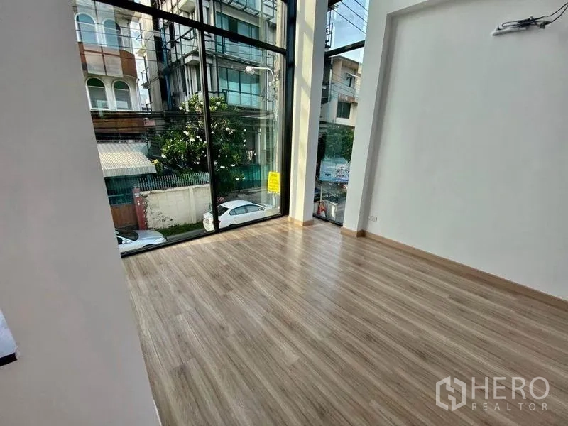 带办公室的家 出售在Wang Thonglang, Bangkok - 转角办公区，通高玻璃与木地板，面向城市街道