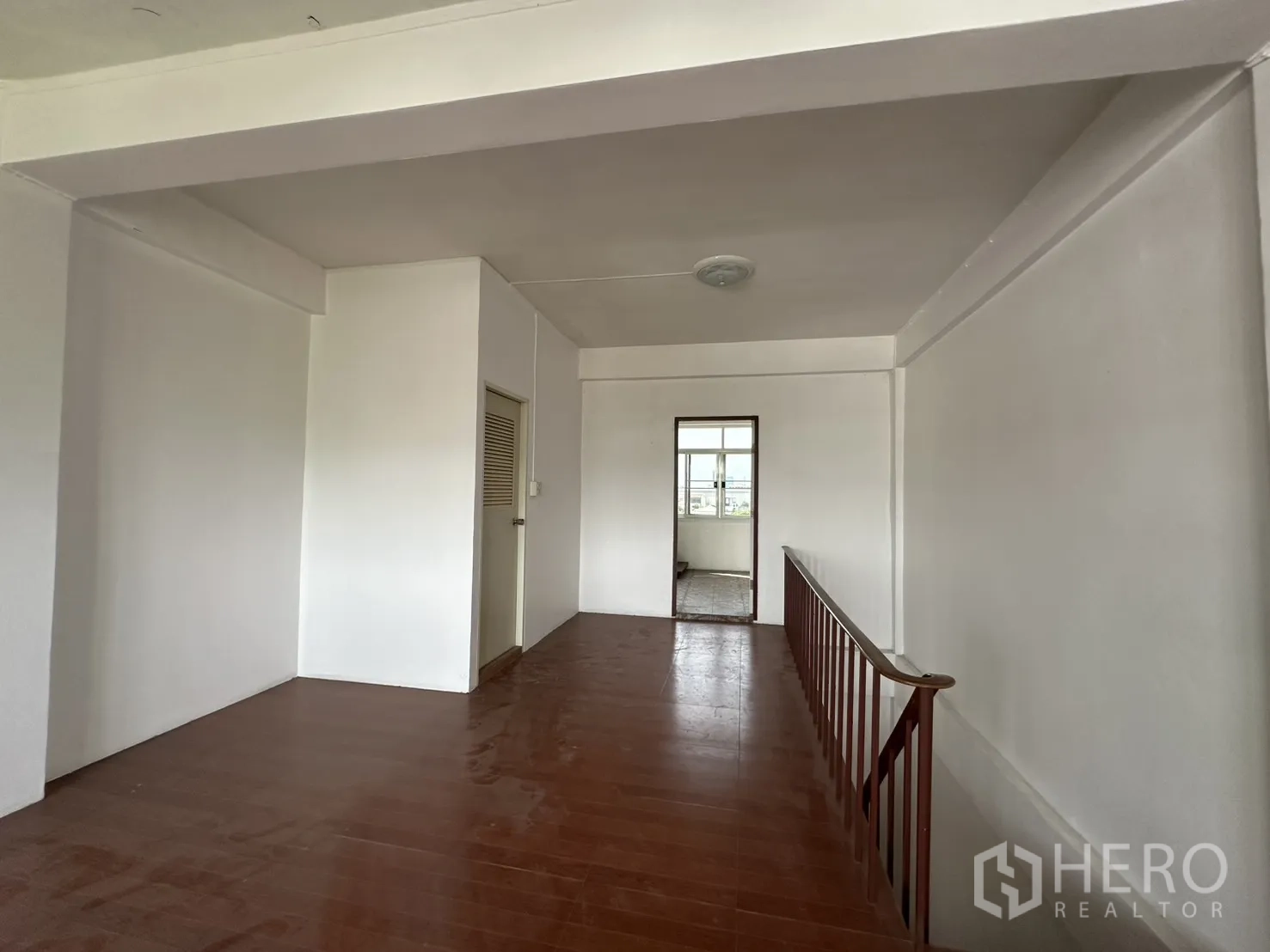Shophouse for rent in Phra Khanong, Bangkok - Hallway with staircase railing and access to rooms.