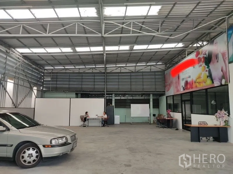 Warehouse for rent in Bueng Kum, Bangkok - Open-plan warehouse with steel roof trusses, natural light panels, concrete floor and glass-partition office area.
