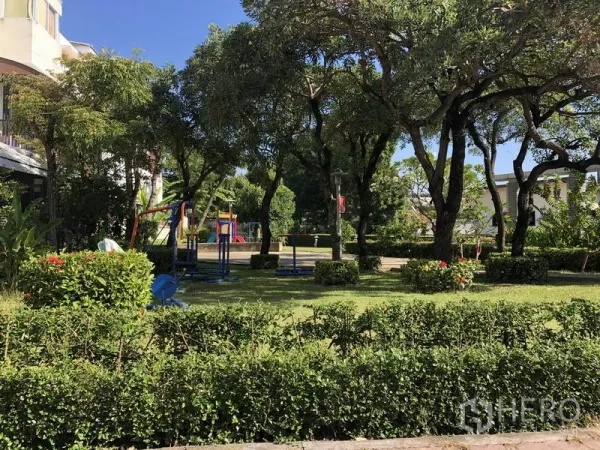 Townhouse for rent in Yan Nawa, Bangkok - Leafy community park with playground equipment and manicured hedges.
