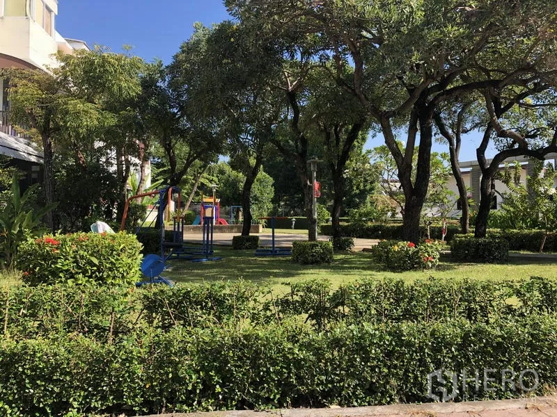 Townhouse for rent in Yan Nawa, Bangkok - Leafy community park with playground equipment and manicured hedges.