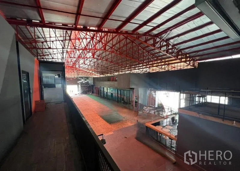 Showroom for rent in Mueang Samut Prakan, Samut Prakan - Balcony corridor overlooking large warehouse with red truss ceiling