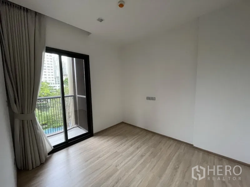 Warehouse for rent in Lam Luk Ka, Pathum Thani - Upper office room with wood-style flooring and a sliding door to a small balcony.