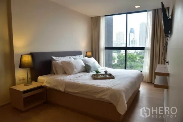คอนโด ให้เช่าในWatthana, Bangkok - ห้องนอนสว่างพร้อมหน้าต่างบานใหญ่ วิวเมือง และโคมไฟข้างเตียง