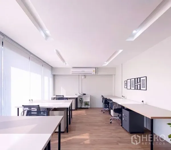 Office Space for rent in Bang Rak, Bangkok - Sunlit open office with multiple desks, swivel chairs, and light wood flooring.