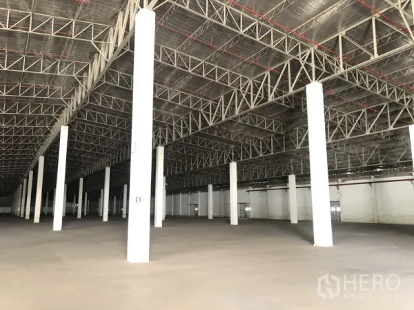 货栈 出租在Lam Luk Ka, Pathum Thani - 斜角视图展示仓库净空高度、钢梁与开阔地面