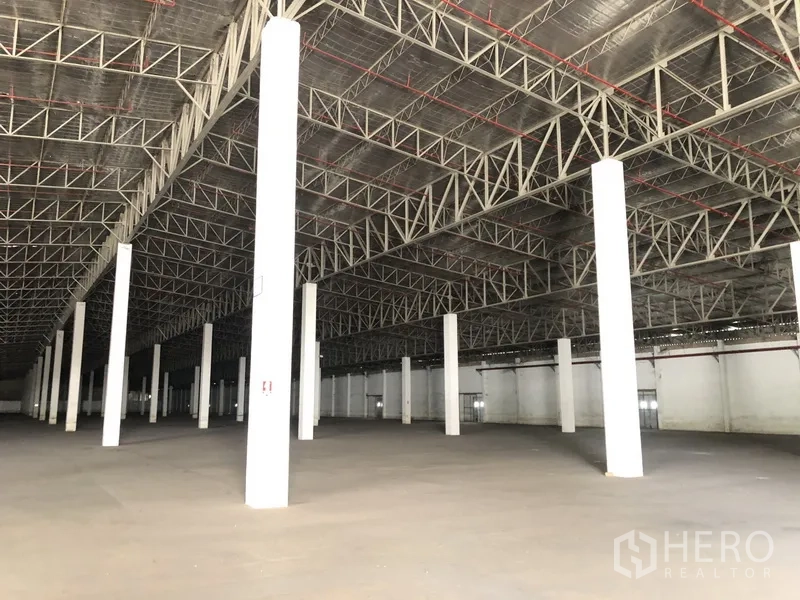 货栈 出租在Lam Luk Ka, Pathum Thani - 斜角视图展示仓库净空高度、钢梁与开阔地面