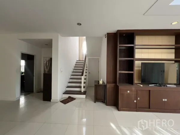 独立式住宅 出租在Bang Kapi, Bangkok - 开放式客厅通向木楼梯，楼梯下有储物空间。
