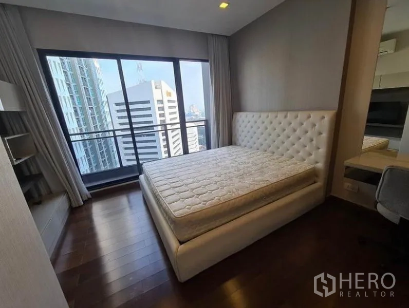 公寓 出租或出售在Huai Khwang, Bangkok - 卧室采光好，软包床头、木地板与大窗城市景观。