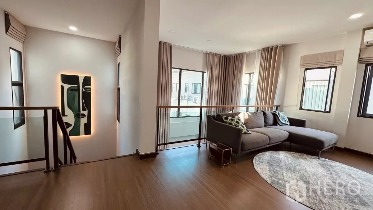 บ้าน ให้เช่าในBang Phli, Samut Prakan - โถงบันไดชั้นสองพร้อมโซฟามุมและหน้าต่างรอบด้านพร้อมผ้าม่าน