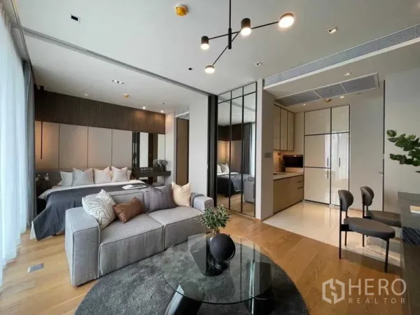 Condominium for rent or sale - Bright living area with sofa, kitchenette and sliding glass partition.