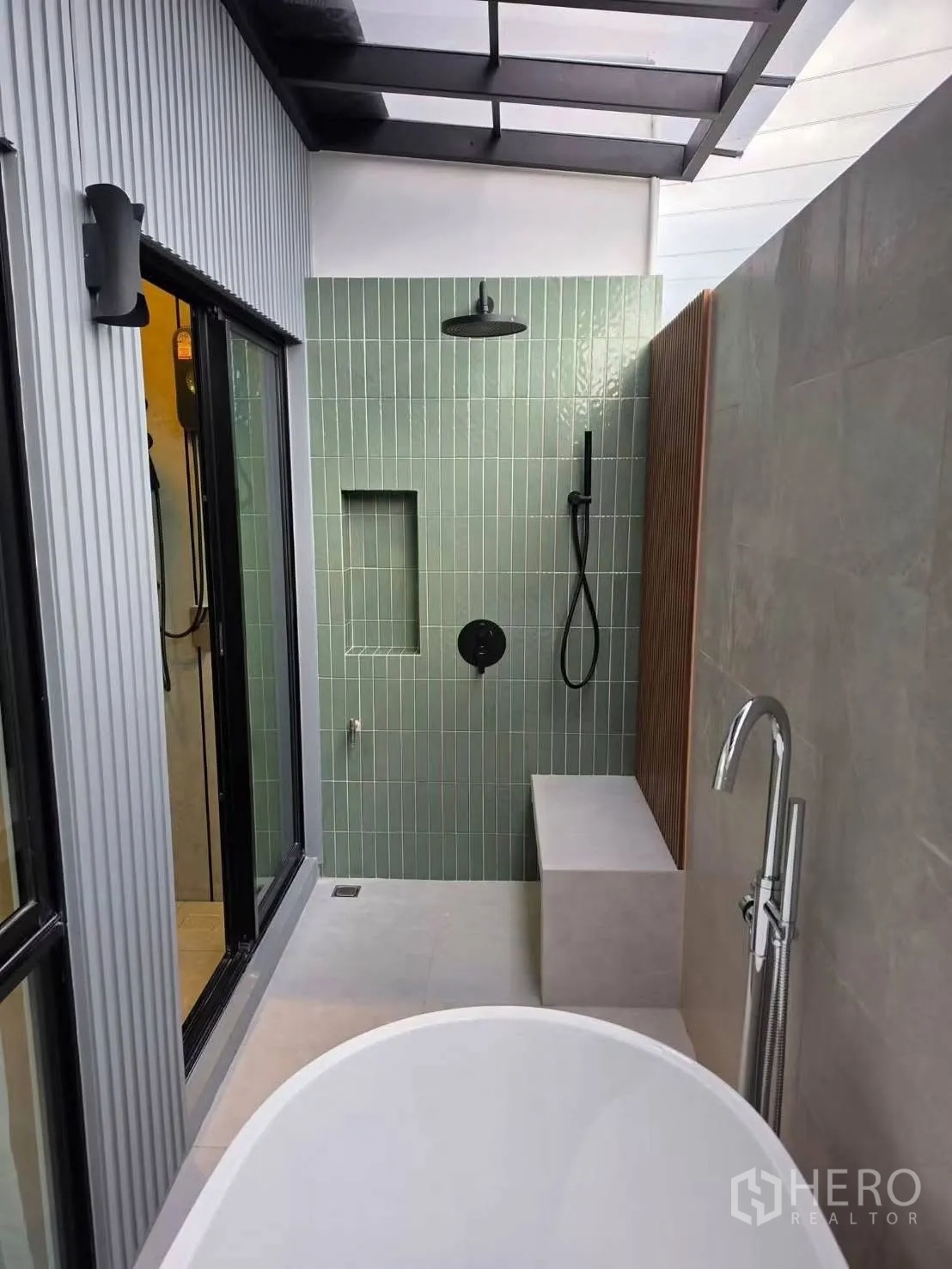 Townhouse for rent in Bang Phli, Samut Prakan - Semi-outdoor shower area with green tile wall, bench, and rain shower beneath a skylight.