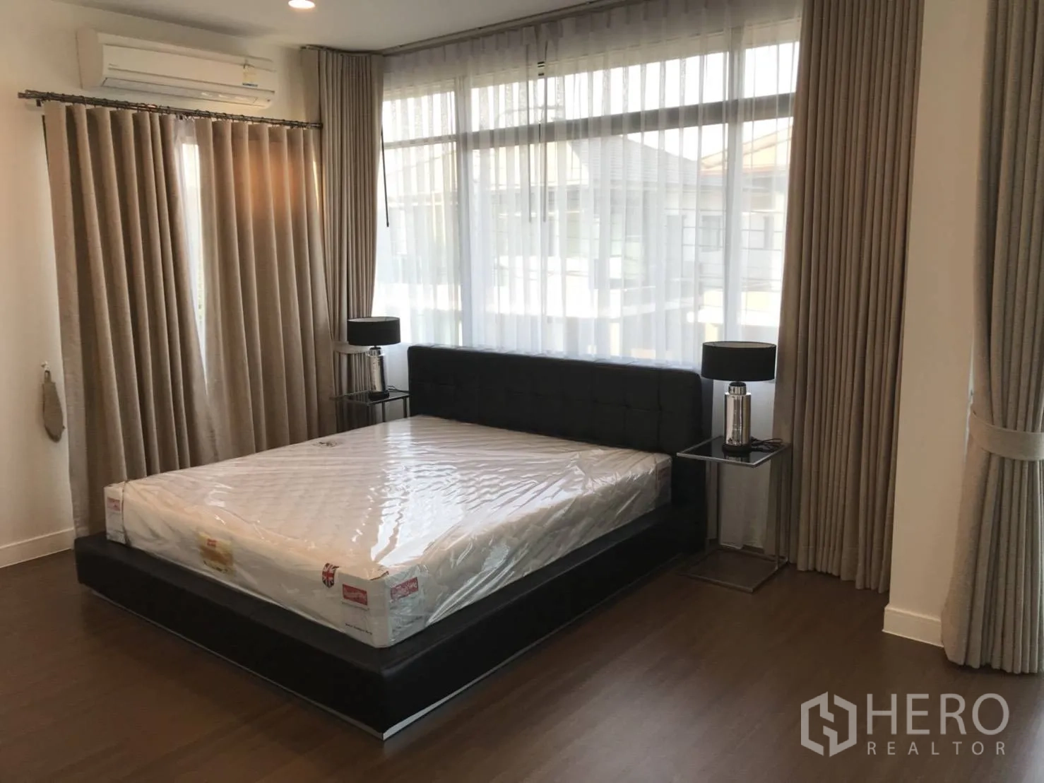 บ้าน ให้เช่าในBang Kapi, Bangkok - ห้องนอนมาสเตอร์ เตียงคู่ โต๊ะข้าง หน้าต่างกว้าง และพื้นไม้
