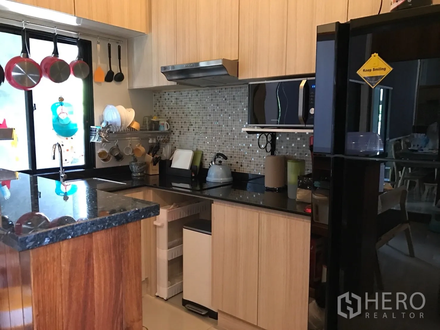 Townhouse for sale in Suan Luang, Bangkok - Built-in kitchen with black granite countertops, light wood cabinets and mosaic backsplash
