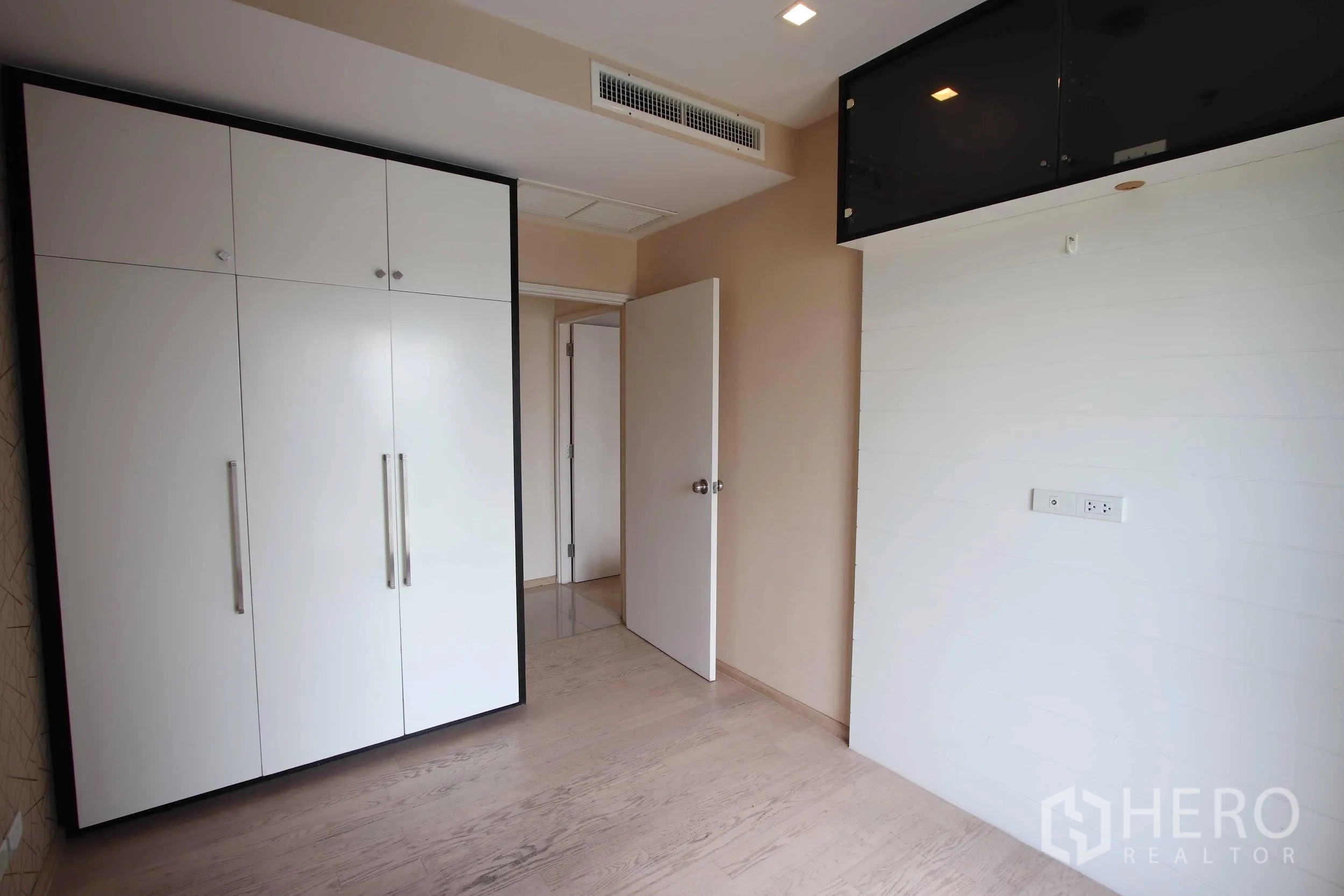 Condominium for rent in Khlong Toei, Bangkok - Second bedroom with light wood flooring, large built-in wardrobe and neutral walls, ready for customization.