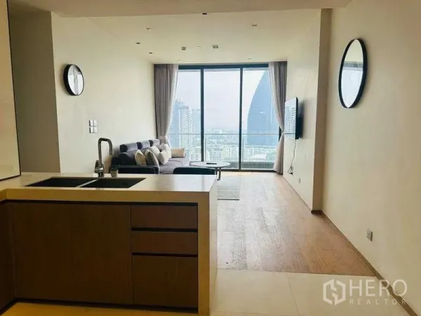 公寓 出租在Khlong Toei, Bangkok - 开放式客厅与厨房，落地窗俯瞰曼谷天际线。
