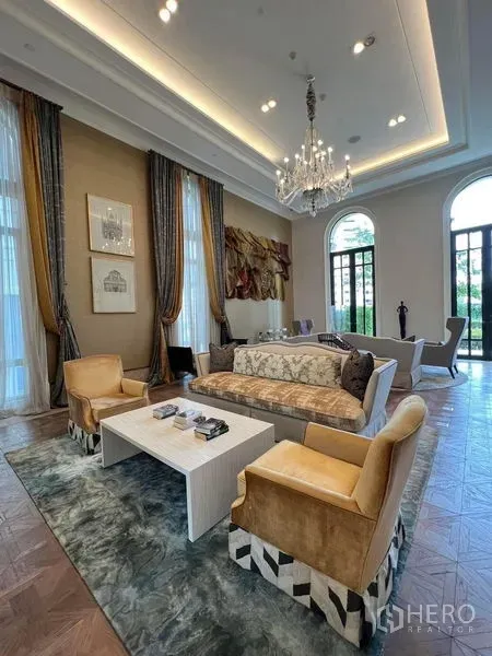 Condominium for rent in Watthana, Bangkok - Residents’ lounge with chandelier, high ceiling, plush seating, and tall windows.
