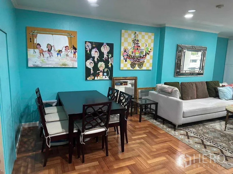 公寓 出租或出售在Bangkok - 餐区有深色木桌、软垫座椅与墙面装饰画。