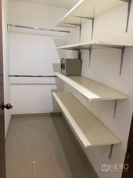 Condominium for rent in Watthana, Bangkok - Walk-in closet with open shelving and hanging rails.
