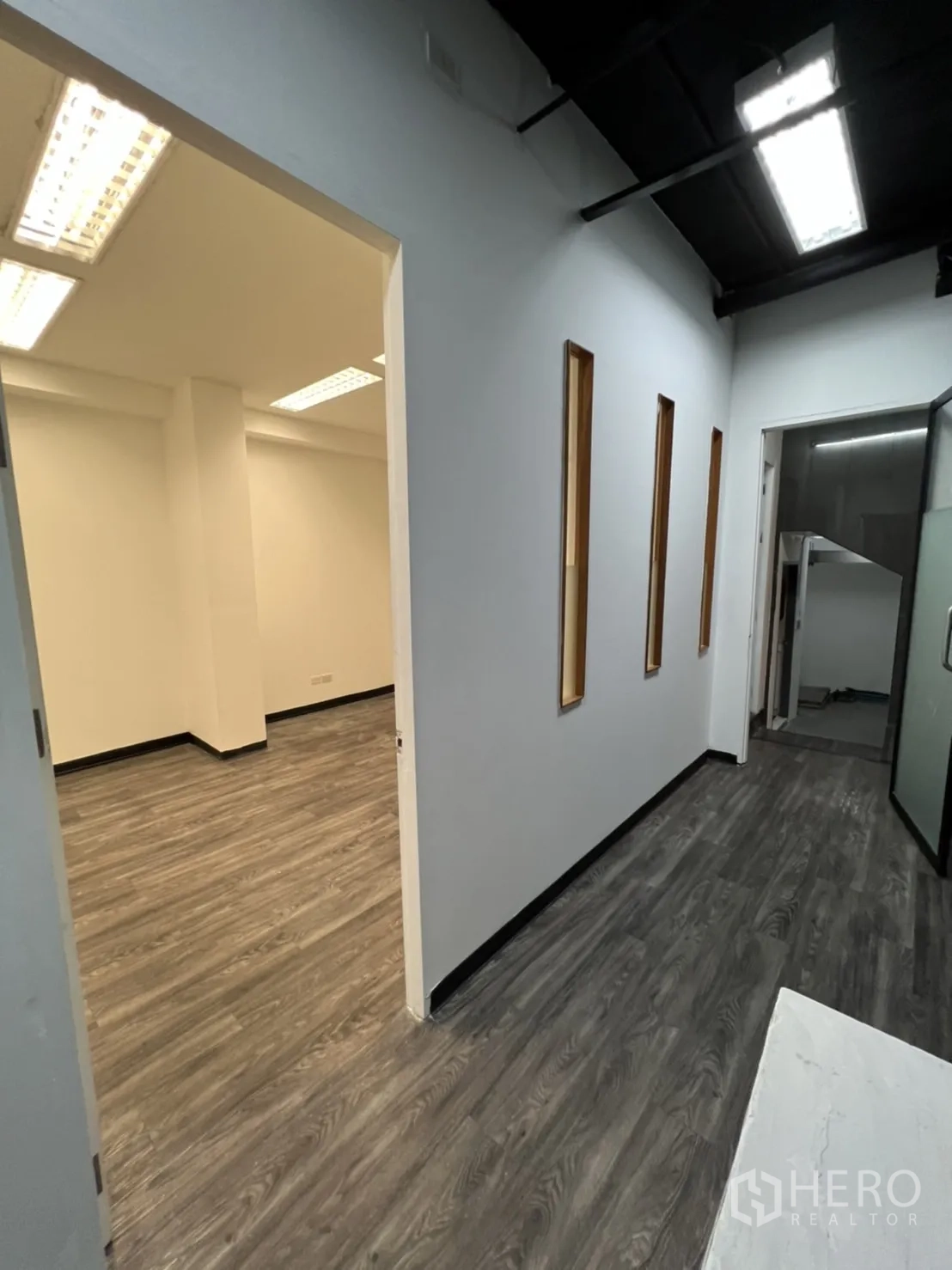 Retail Space for rent in Sathon, Bangkok - Corridor with gray wood flooring opening into bright office rooms.