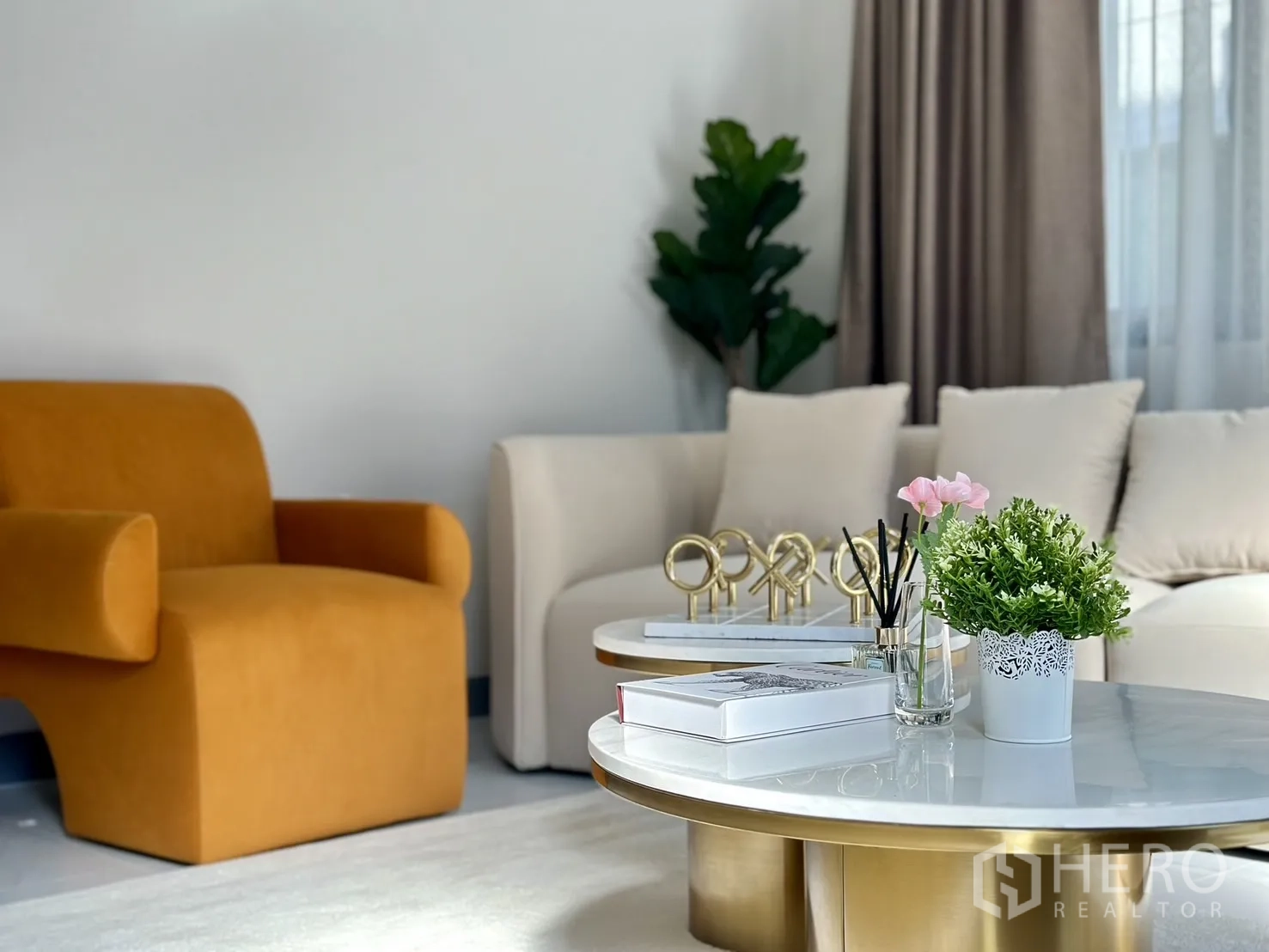 Detached House for rent or sale - Seating area featuring mustard armchair, cream sofa and coffee tables decorated with plants and tray accents.
