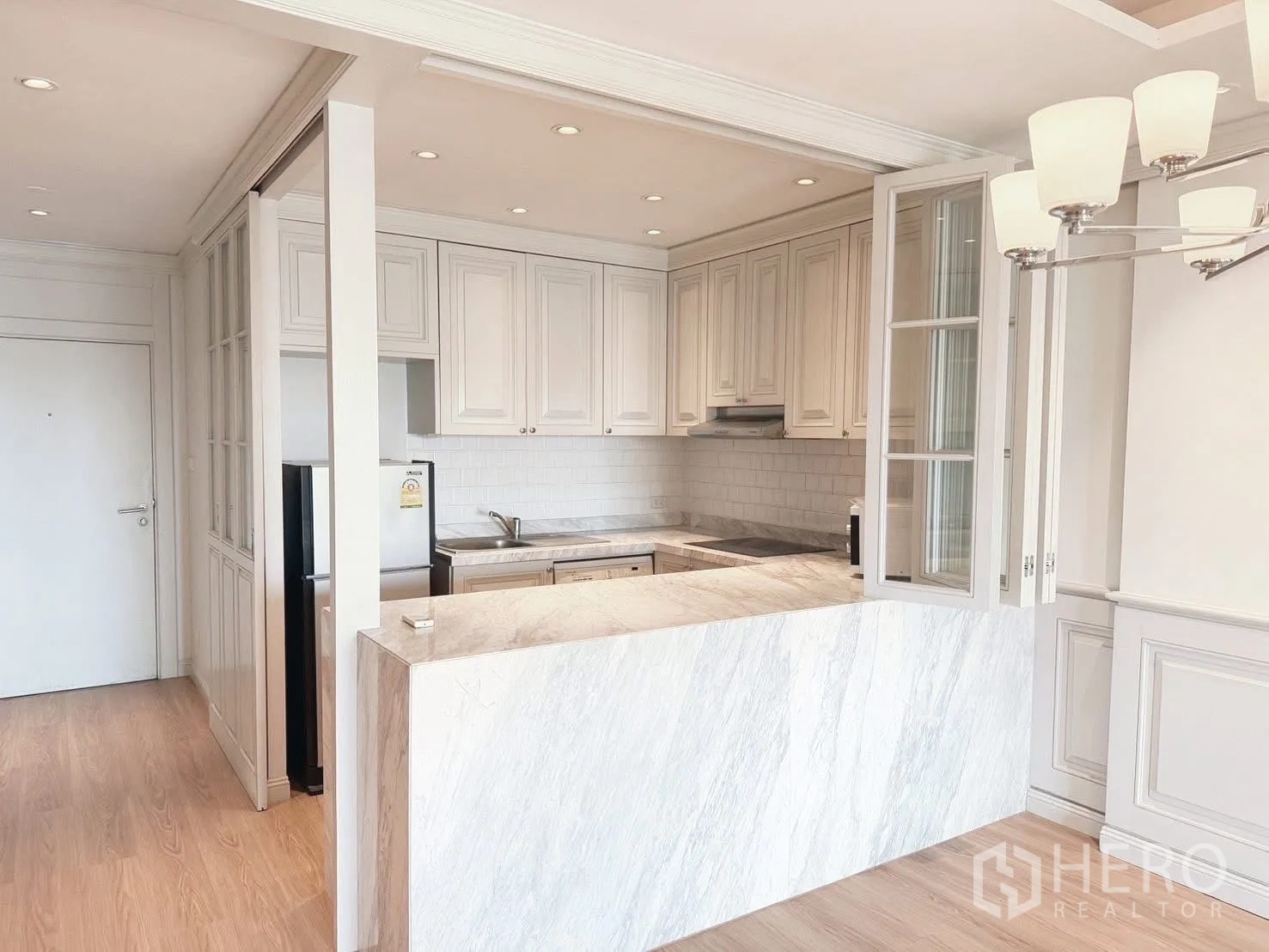 Condominium for rent or sale in Sathon, Bangkok - Semi-open kitchen to dining with marble breakfast bar and chandelier.