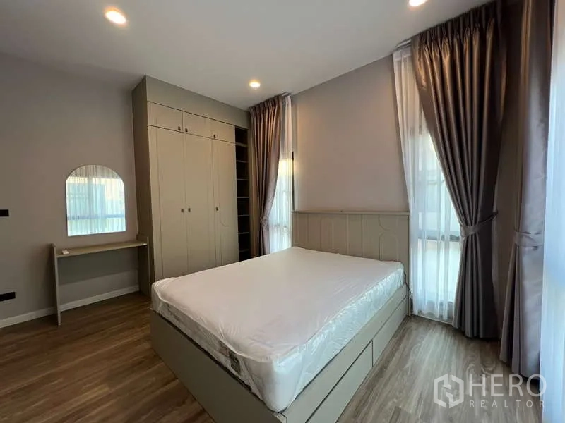 Detached House for rent in Bang Kapi, Bangkok - Bedroom with built-in wardrobe, vanity desk and bedside windows.
