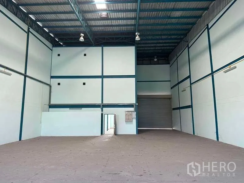 Warehouse for rent in Bang Phli, Samut Prakan - Warehouse bay showing roller shutter door, internal rooms and electrical panel.