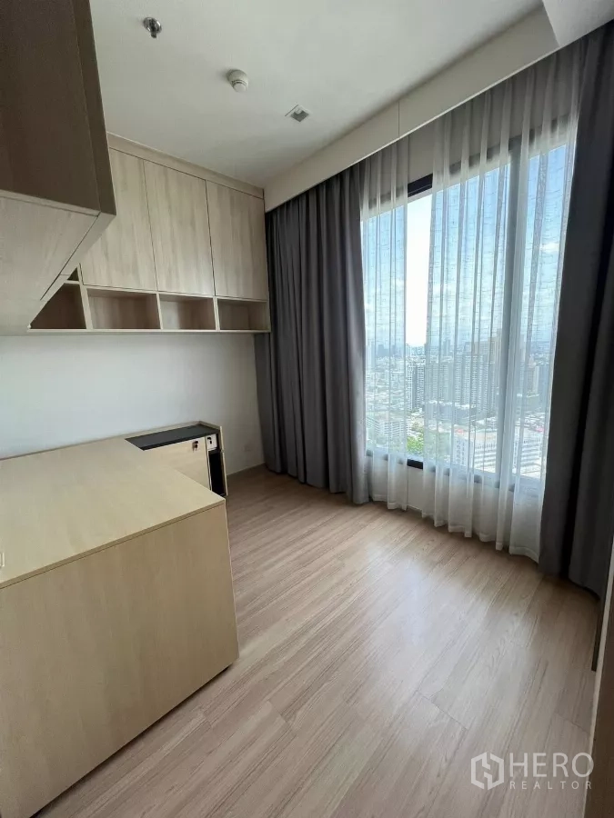 Condominium for rent or sale in Chatuchak, Bangkok - Second bedroom or study with large window, city view and overhead cupboards.