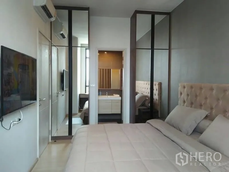 公寓 出租在Huai Khwang, Bangkok - 主卧带镜面衣柜、软包床头，并可进入套内卫浴。
