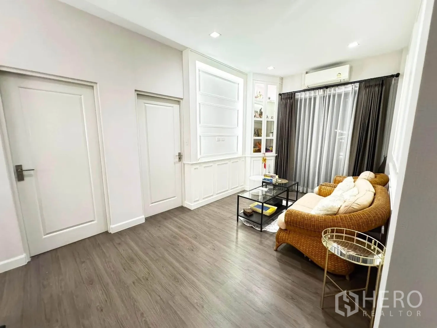 Detached House for rent in Saphan Sung, Bangkok - Cozy sitting area with wicker sofa, glass coffee table, and full-length curtains.