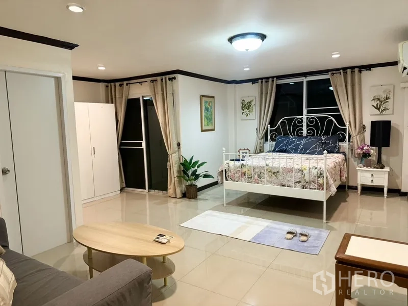 联排别墅 出租在Prawet, Bangkok - 宽敞主卧，金属床架、阳台门与大窗户。