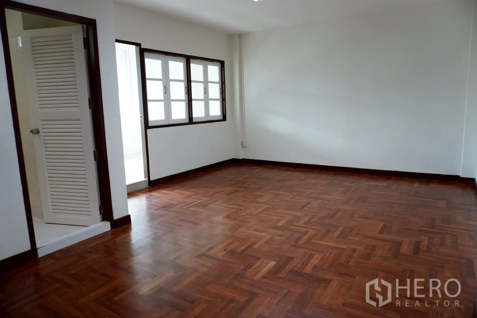 带办公室的家 for rent in Watthana, Bangkok - 转角房，木地板、卫生间门与成排窗户。