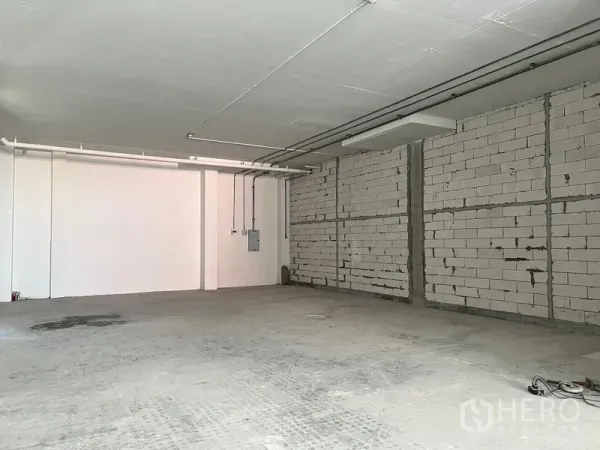 Retail Space for rent - Unfitted retail shell with exposed block walls, ceiling conduits and concrete floor.