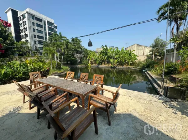 บ้านเดี่ยว for rent or sale in Mueang Samut Prakan, Samut Prakan - ชานนั่งเล่นพร้อมชุดโต๊ะไม้ริมบ่อน้ำบรรยากาศสงบ