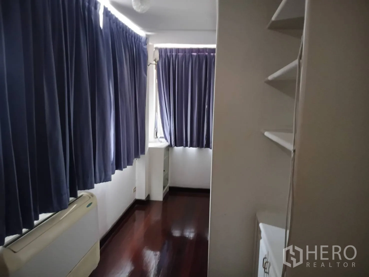 独栋房屋 for sale in Watthana, Bangkok - 狭长房间配蓝色窗帘、壁架和空调机组。