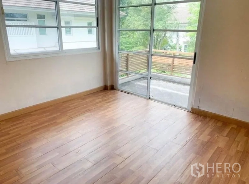 Detached House for sale in Saphan Sung, Bangkok - Bedroom with floor-to-ceiling sliding door opening to a small balcony and garden views.
