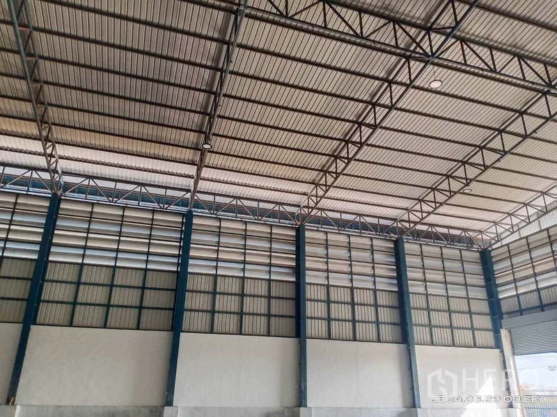 Warehouse for rent in Bang Bo, Samut Prakan - Open interior ceiling featuring steel truss system and continuous ventilation panels.