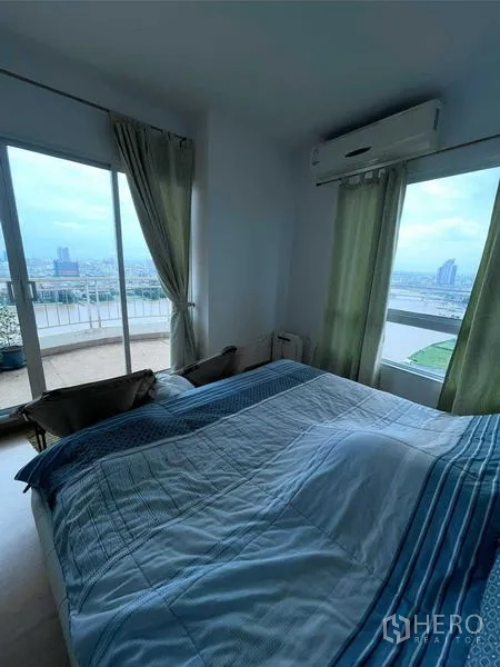 คอนโด ขายในBangkok - ห้องนอนใหญ่มีหน้าต่างบานใหญ่และประตูสไลด์สู่ระเบียง เห็นวิวแม่น้ำ