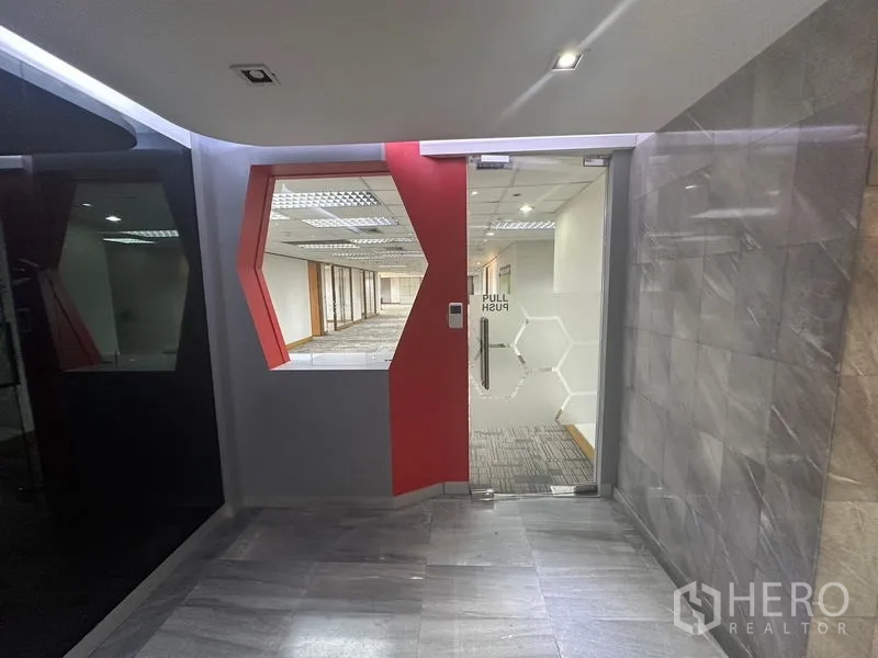 Office Space for rent in Khlong Toei, Bangkok - Secure glass entry with keycard access and a geometric red accent wall.