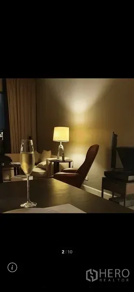 Condominium for rent in Watthana, Bangkok - Warm evening lounge with table lamp, armchair and TV console creating a relaxed ambiance.