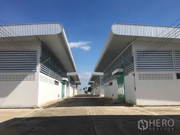 Warehouse for rent in Nong Chok, Bangkok - Row of new warehouse units facing a wide internal driveway inside a secure compound.