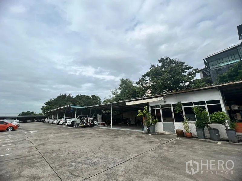 ที่ดิน ให้เช่าในBang Na, Bangkok - ลานหน้ากว้างพื้นคอนกรีต รายล้อมด้วยโรงเรือนมีหลังคาและพื้นที่สีเขียว