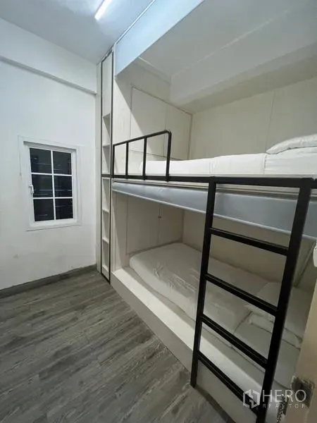 Shophouse for rent or sale in Watthana, Bangkok - Compact room with built‑in double bunk beds, metal ladders and wood‑look flooring.